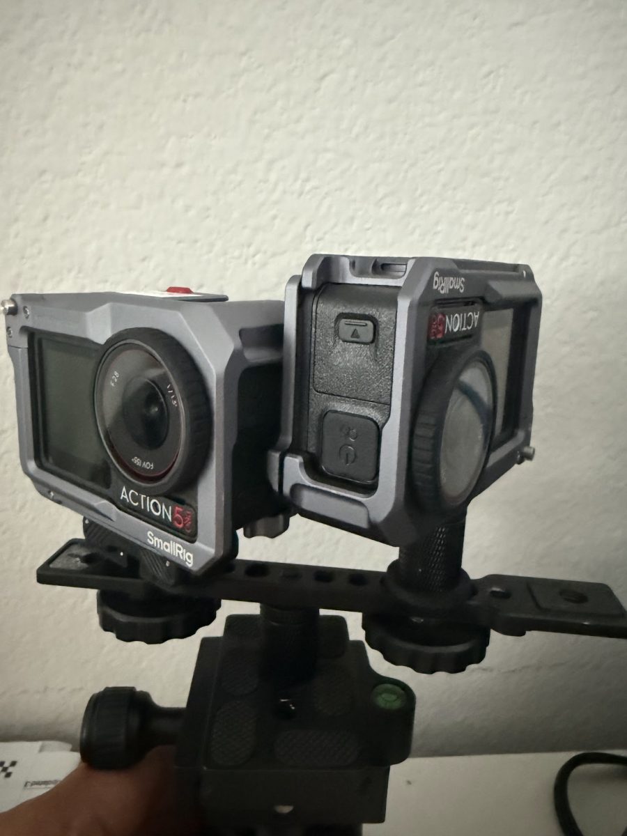 Two DJI Osmo Action 5 Pro cameras in SmallRig cages on a small dual-mount bar, one camera mounted upside down, with a bubble level on the mount below